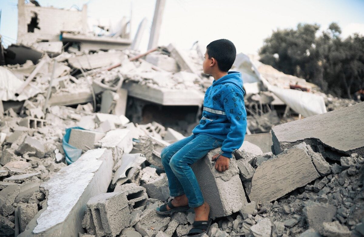 A boy sitting on rubble in the Gaza strip.