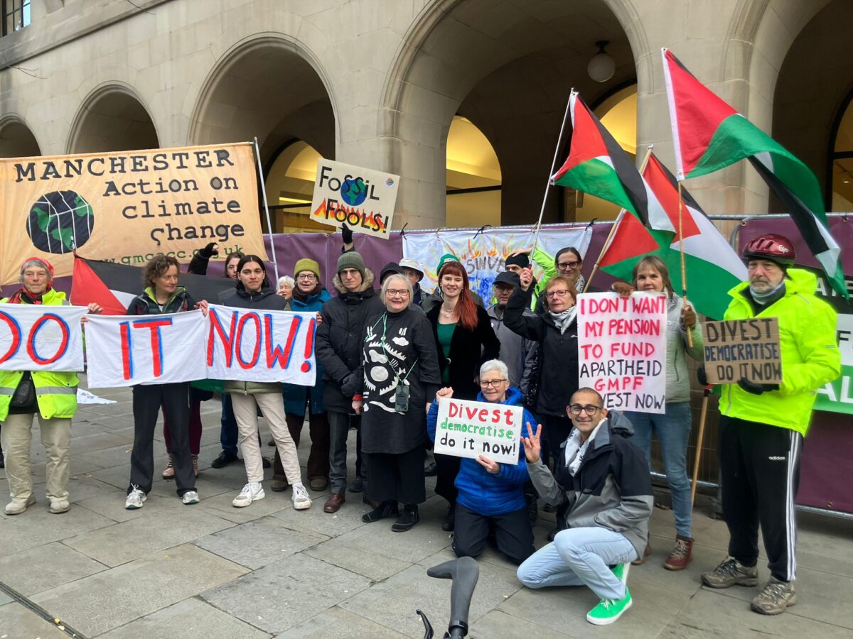 Manchester's Green councillors with supporters holding banners outside Manchester Town Hall